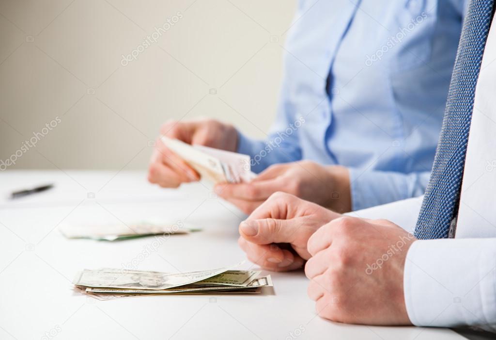 Business people counting banknotes