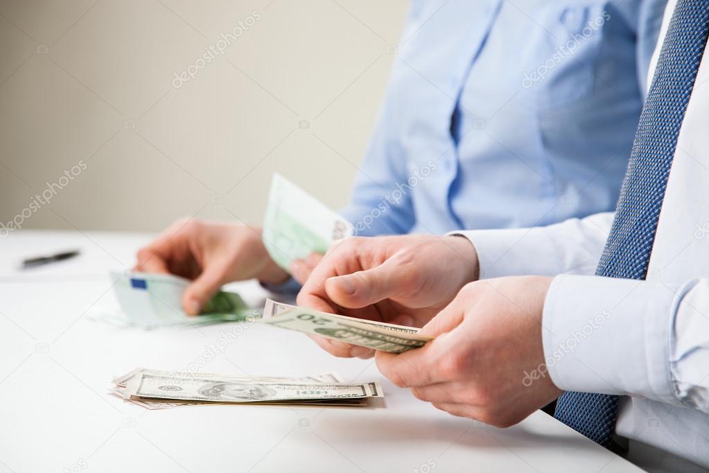 Business people counting banknotes