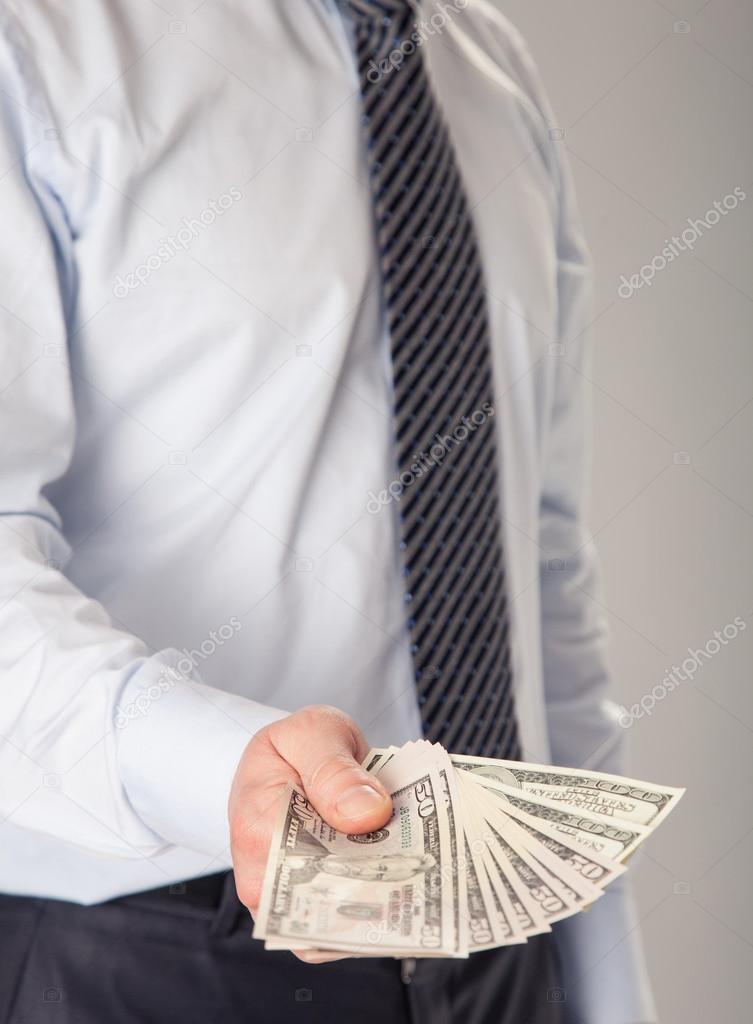 Businessman giving banknotes to you
