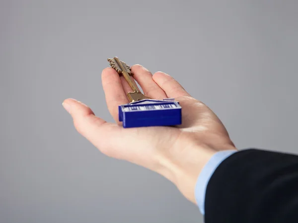 Real estate agent's hand holding a key — Stock Photo, Image