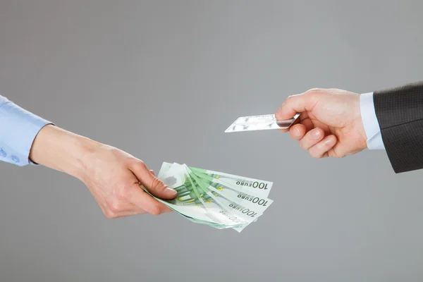 Empresários trocando cartão de crédito e dinheiro — Fotografia de Stock