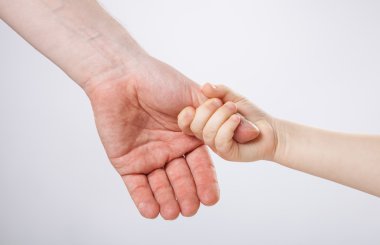 Baba'nın baş parmağını tutan çocuk