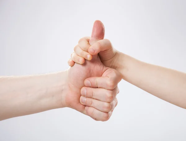 Barnet håller pappas tumme finger — Stockfoto