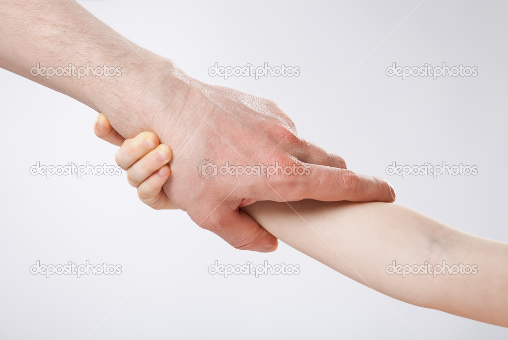 Hands of a child and a father holding each other