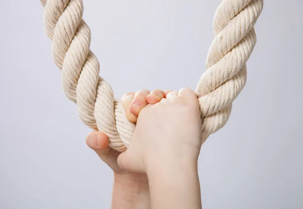 Cheerful little girl hanging on a rope — Zdjęcie stockowe