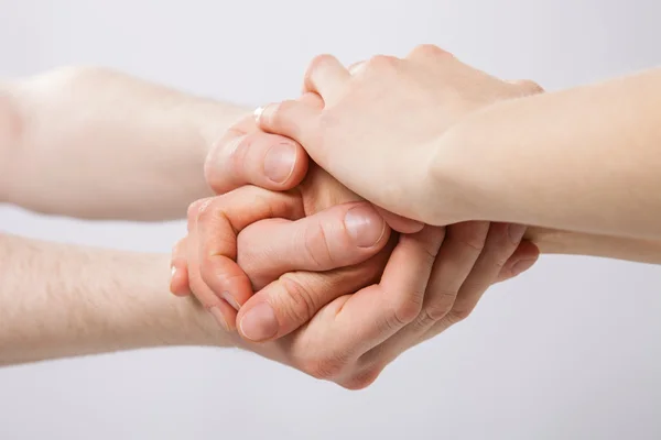 Förenade händer på grå bakgrund — Stockfoto