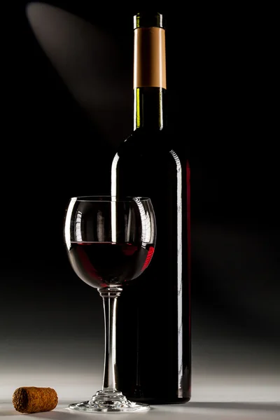 赤ワインとワインのボトルを開けたの満たされたガラス — ストック写真