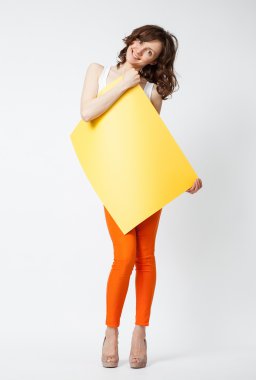 Turuncu pantolonlu sarı kağıt tutan oynak genç kadın
