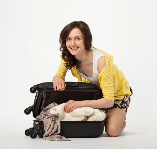 Приваблива жінка упаковує валізу — стокове фото