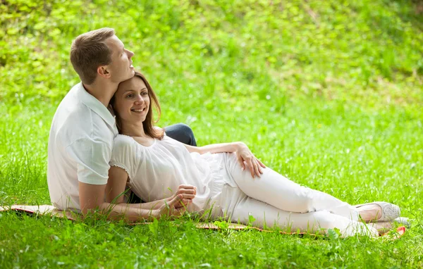 Casal amoroso tendo tempo juntos em um prado verde — Fotografia de Stock