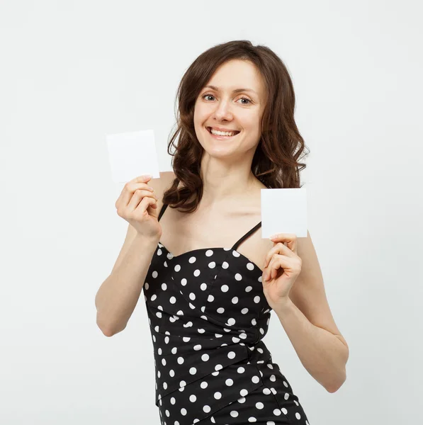 Aantrekkelijke jonge vrouw lege witte kaarten tonen — Stockfoto