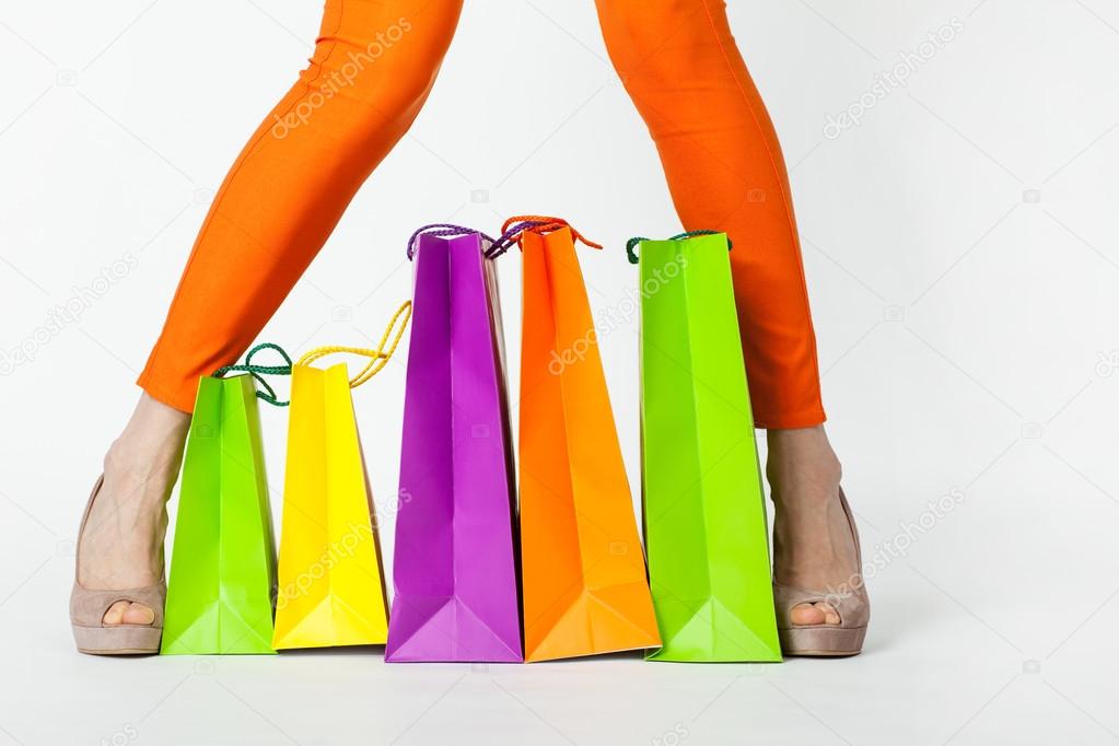 Woman's legs in orange pants and shopping bags
