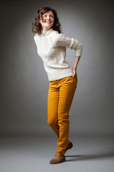 Happy young woman posing in a studio — Stock Photo, Image