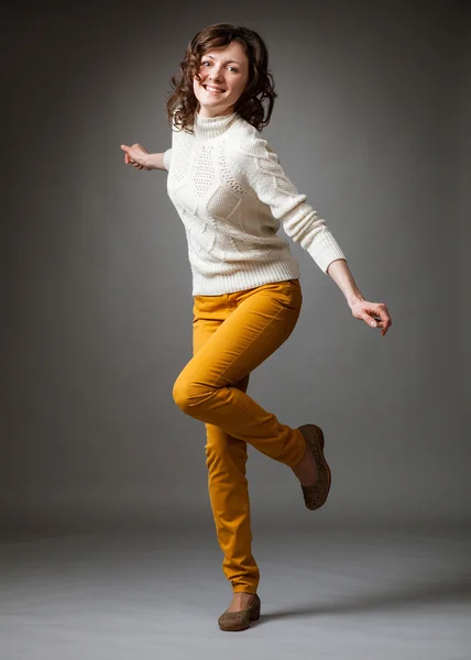 Happy young woman in sweater posing in a studio — Stock Photo, Image