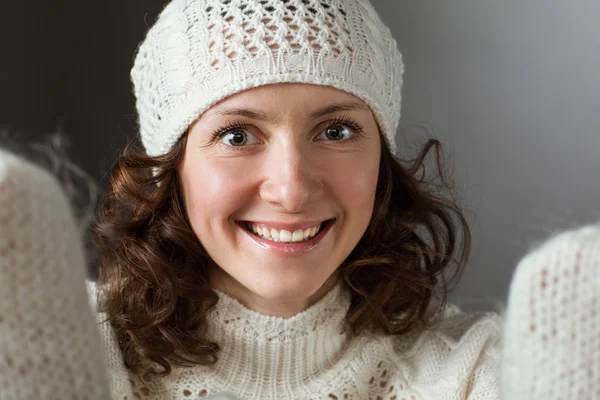 Speelse lachende jonge vrouw in witte wanten — Stockfoto