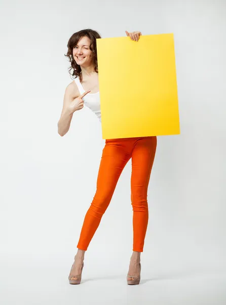 Jovem brincalhão segurando cartaz amarelo em branco — Fotografia de Stock