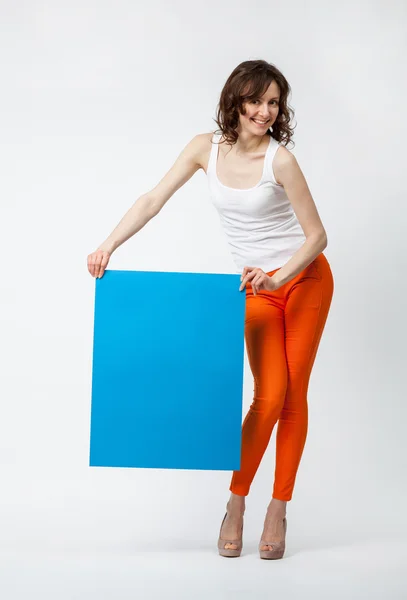 Playful young woman holding blue placard — Stock Photo, Image