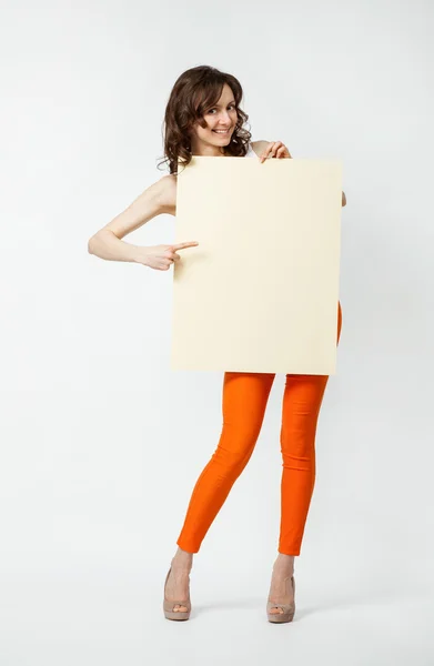 Playful young woman holding blank placard — Stock Photo, Image
