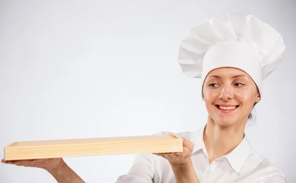Mulher chef cozinheiro segurando placa de madeira — Fotografia de Stock