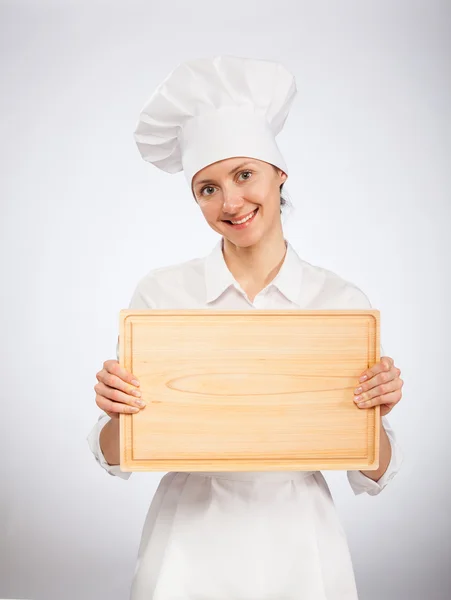 Mulher sorridente chef cozinheiro segurando placa de madeira — Fotografia de Stock