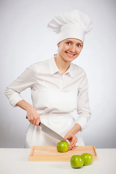 Female cook cutting  green apple — Stock Photo, Image