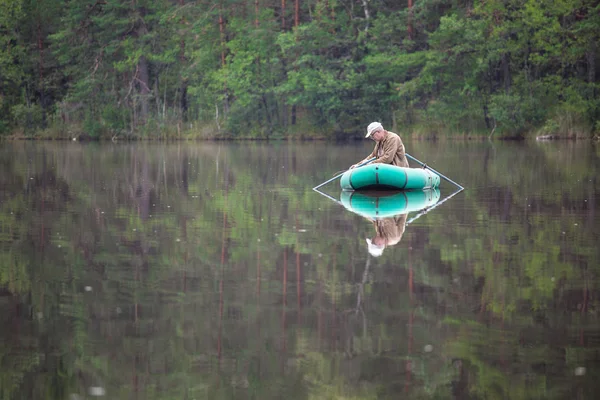 Senior mens vissen vanaf een boot — Stockfoto