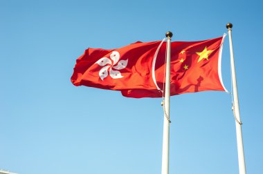 hong kong ve Çin Ulusal bayrakları karşı mavi gökyüzü uçan