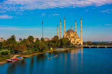 Adana 'daki Sabancı Merkez Camisi (Türkçe: Sabancı Merkez Cami) ve Seyhan Nehri. Türkiye 'nin mavi gökyüzüne sahip en büyük camii.