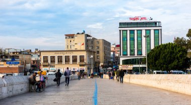 ADANA, TURKEY - 4 Aralık 2021: TASKOPRU (Taş Köprü) üzerinde yürüyen insanlar. ADANA, TURKEY. Seyhan Nehri üzerindeki tarihi taş köprü.