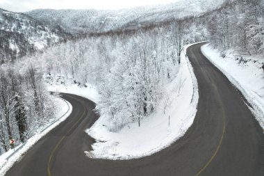 A sharp turn on a winding road in the forest. KARTEPE, KOCAELI, TURKEY. Beautiful winter landscape aerial view.