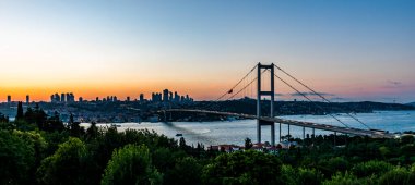 İSTANBUL, Turkey. Günbatımında İstanbul Boğazı 'nın panoramik manzarası. İstanbul Boğaz Köprüsü (15 Temmuz Şehitler Köprüsü. Türkçe: 15 Temmuz Sehitler Koprusu). Güzel bulutlu mavi gökyüzü.
