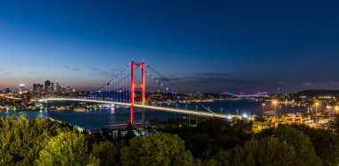 İSTANBUL, Turkey. Günbatımında İstanbul Boğazı 'nın panoramik manzarası. İstanbul Boğaz Köprüsü (15 Temmuz Şehitler Köprüsü. Türkçe: 15 Temmuz Sehitler Koprusu). Güzel bulutlu mavi gökyüzü.