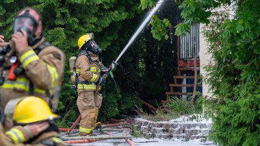 Firefighters at work during a house fire, with respiratory protection equipment
