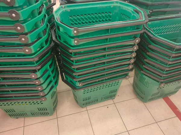 超级市场购物车轮子上的一堆堆空的绿色塑料篮子 — 图库照片