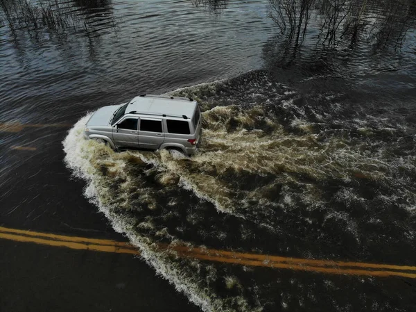 Een Auto Die Een Overstroomde Weg Overwint Tijdens Een Lenteoverstroming — Stockfoto