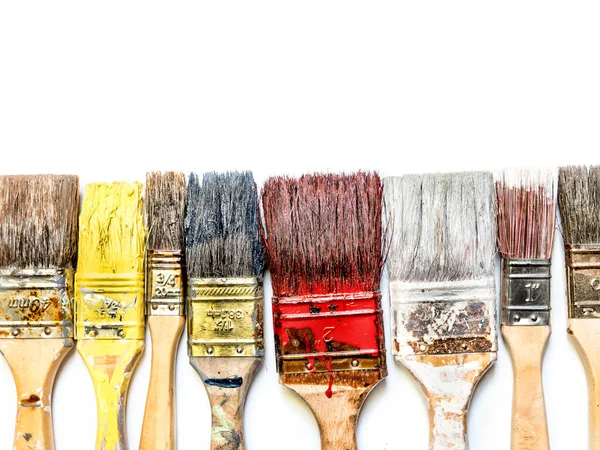 Kullanılmış ve kurutulmuş boya fırçaları yukarıdan beyaz bir sıra üzerine yerleştirilmiş.