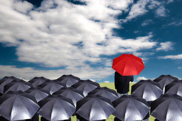 Leader holding red umbrella for show different think — Stock Photo, Image