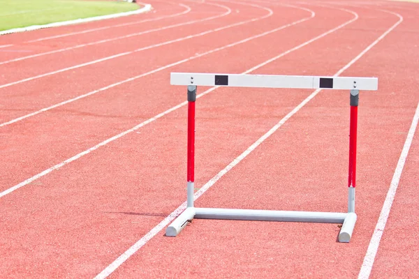 Hurdles on the red running track — Stock Photo, Image