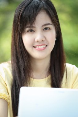 Asyalı genç kız arama bilgi için dizüstü bilgisayar kullanmak 