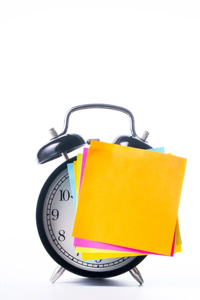 Opmerking kleur papier stok op alarm clock — Stockfoto