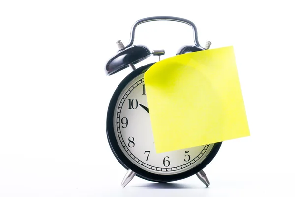 Opmerking kleur papier stok op alarm clock — Stockfoto