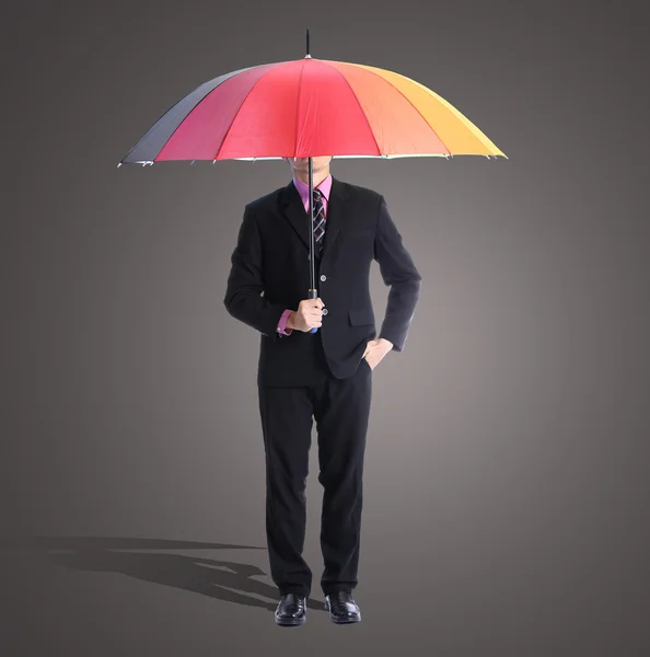 Businessman holding rainbow umbrella — Stock Photo, Image