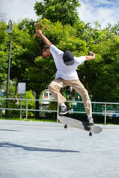 Skateboard man flip board in the sport area.Sport man funny with his hobby in the outside.