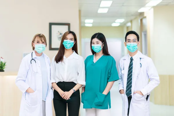 看護師と白人医師のチームと病院に立つ患者の女性とアジアの医師 — ストック写真