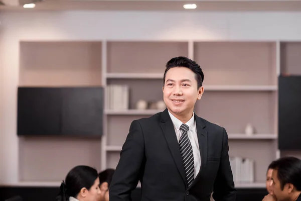 現代オフィスに立つスーツ姿のアジア人ビジネスマンの肖像 — ストック写真