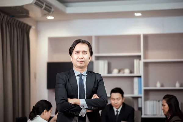 직장에서 양복을 있거나 팔짱을 아시아 사업가의 로열티 프리 스톡 사진