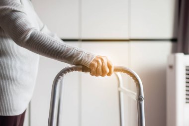 Kıdemli kadın, Walker 'ın elini tutuyor. Eve yürümeye çalışıyor. Fizik tedavi konsepti.