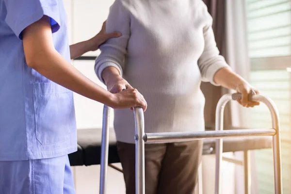 Enfermera Ayudando Una Mujer Mayor Sosteniendo Mano Caminante Tratando Caminar —  Fotos de Stock