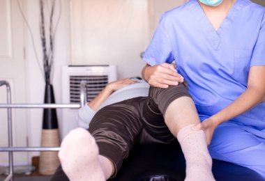 Klinikteki yaşlı kadın hastaya fizyoterapist, yaşlı kadınların diz ağrısı, fizik tedavi konsepti.