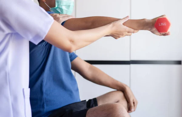 Fisioterapeuta Mujer Formación Con Hombre Paciente Utilizando Pesas Clínica Concepto Imagen De Stock